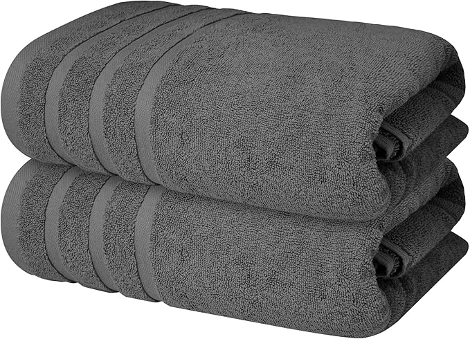 Two dark gray BRIT DIAMOND 100% cotton bath sheets, from the pack of 2 or 4 options, are neatly stacked. These large, soft, and absorbent towels feature simple linear patterns at the ends for a stylish touch.