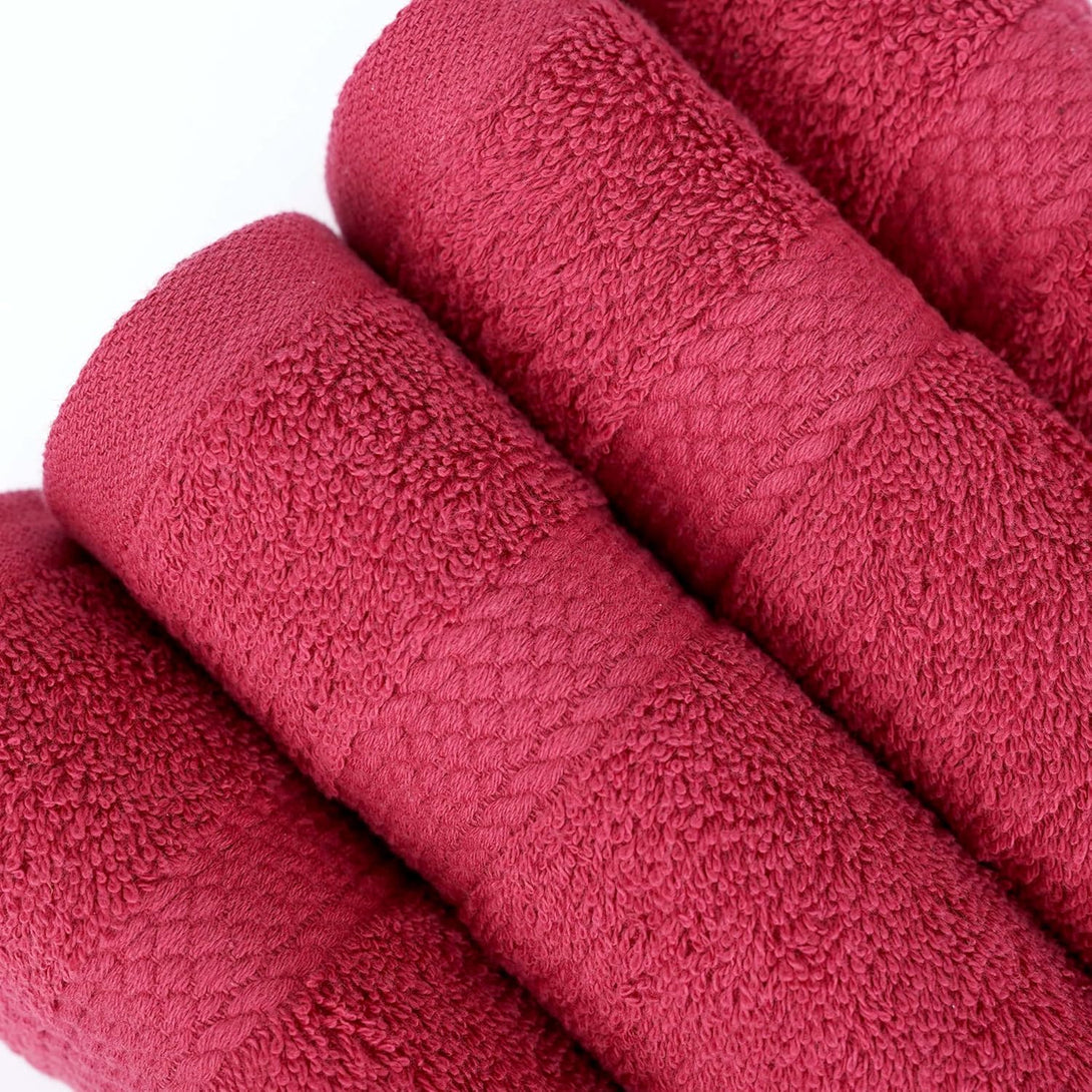 Four soft, textured 100% cotton BRIT DIAMOND bath towels in dark pink are shown rolled side by side. Sold as a pack of 2 or 4, these quick-dry, absorbent towels add style and function to your bathroom. Multiple colours available.