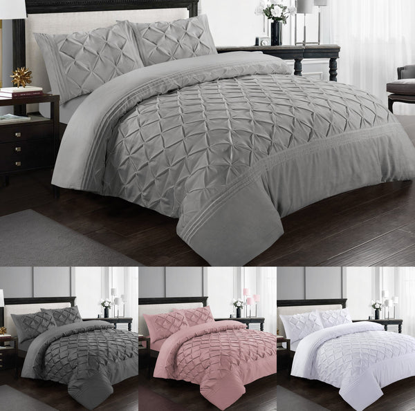 A modern bedroom features the BRIT DIAMOND Deluxe Pinch Pleated Duvet Cover Set—soft 100% cotton pintuck bedding with pillowcases—shown in gray, dark gray, pink, and white for a touch of luxury.
