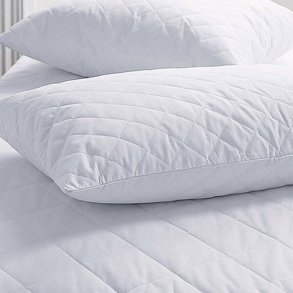 Two large white pillows rest on the BRIT DIAMOND Quilted Mattress Protector 100% Cotton, a fitted bed cover thats clean, soft, anti-allergic, machine washable, and available in all UK sizes with extra deep 30cm & 40cm options.