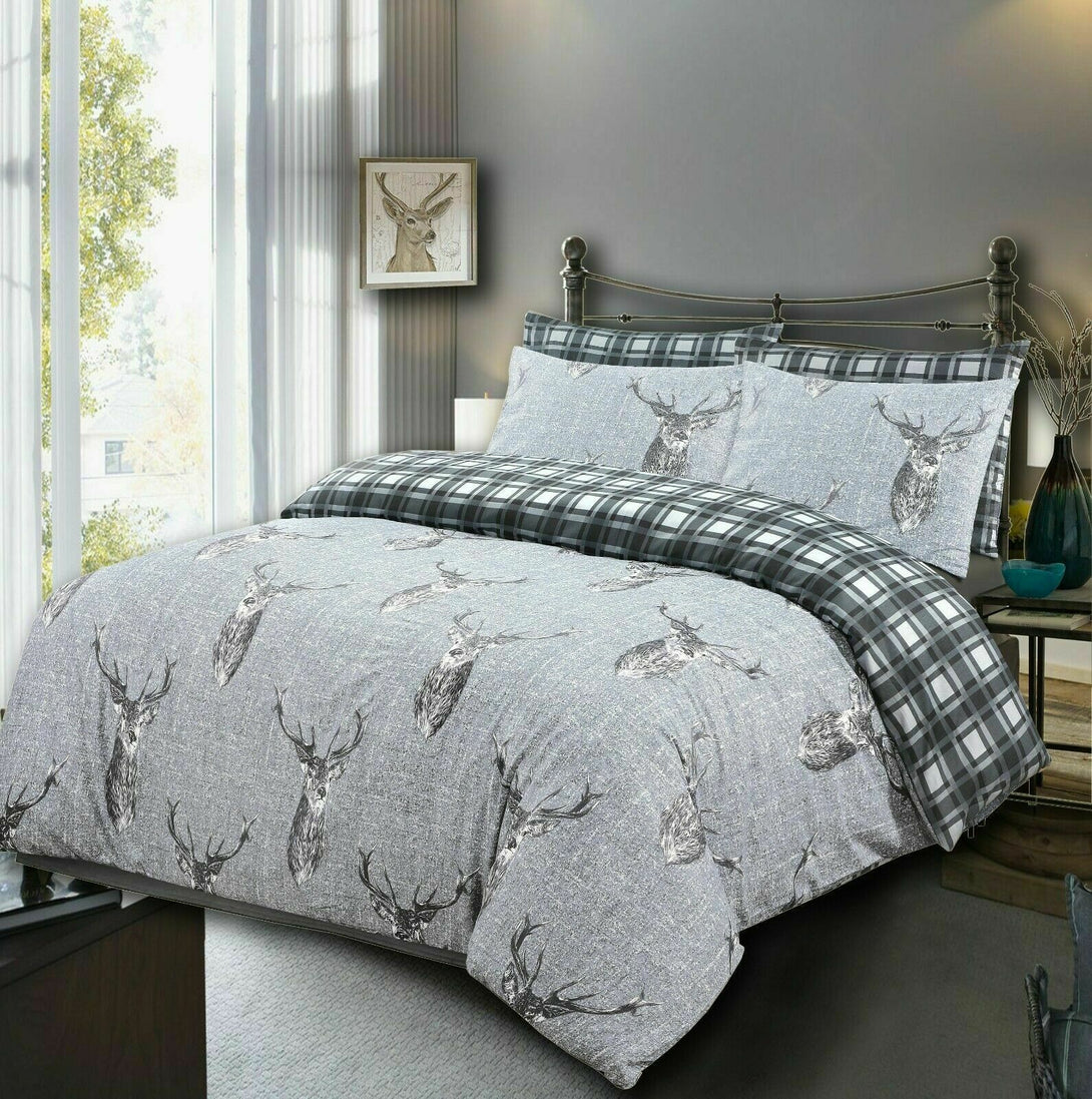 A neatly made bed with BRIT DIAMOND’s 100% Cotton 200TC Reversible Duvet Cover Set, Double & Super King, features stag head prints and matching pillowcases. The room includes a metal headboard and deer artwork in sunlight.