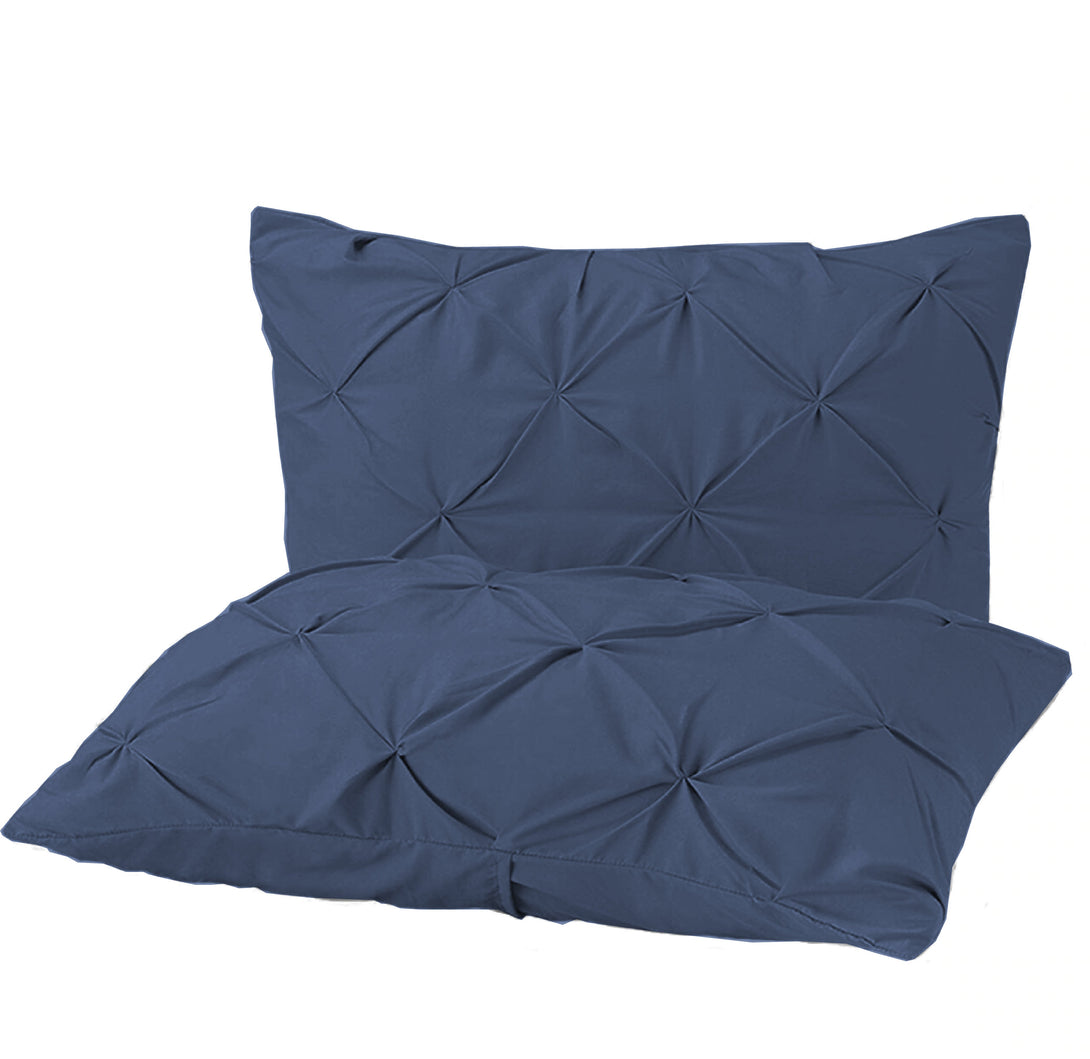 Two navy blue pillowcases from the BRIT DIAMOND Pintuck Duvet Set, made of 100% Egyptian cotton with a tufted pintuck design, are stacked against a white background.