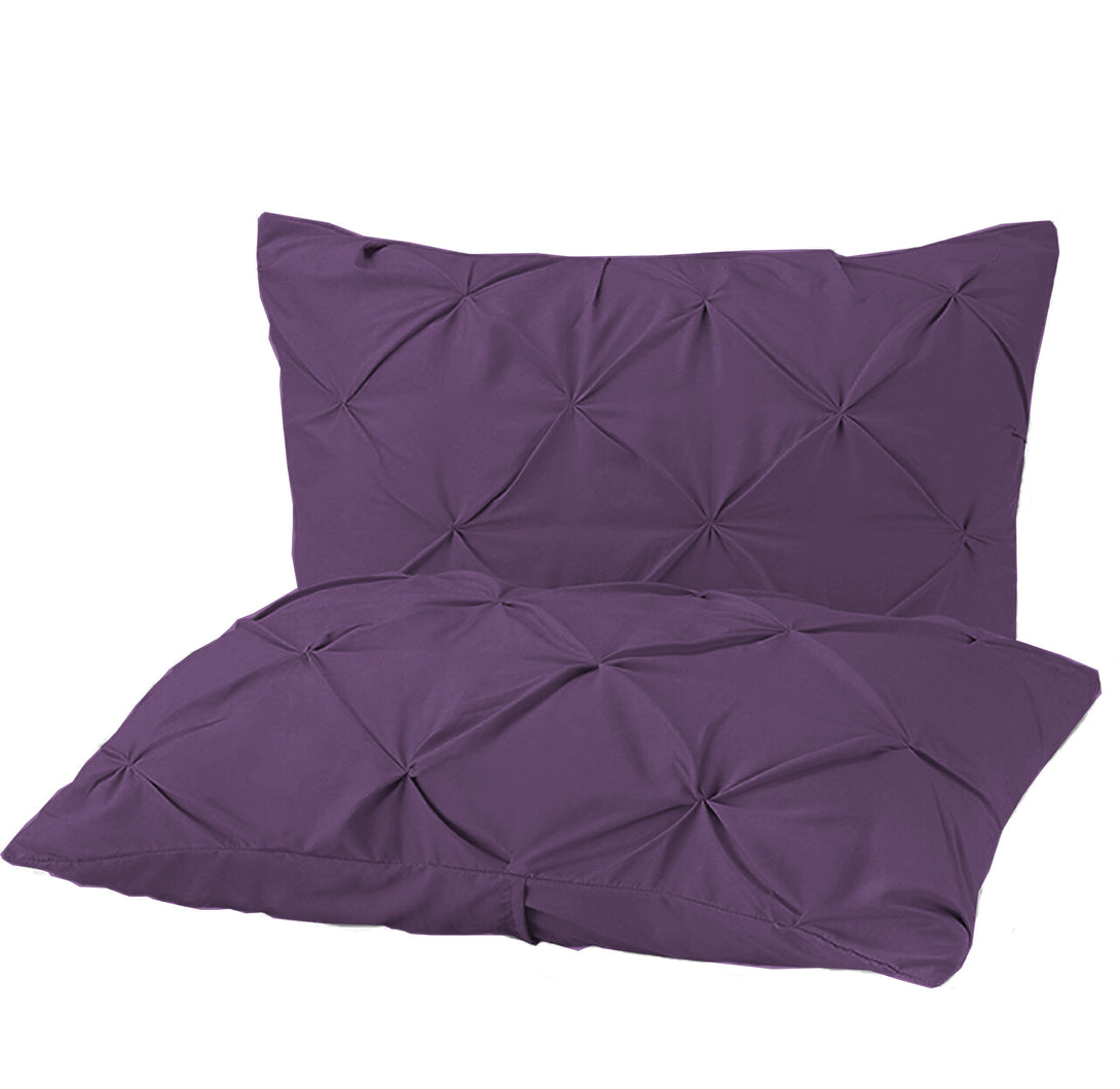 Two purple BRIT DIAMOND Pintuck Duvet Set pillow shams, crafted from 100% Egyptian cotton, display a pintuck geometric design and are stacked elegantly against a white backdrop.